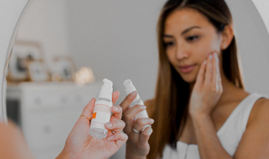 Woman applying LATHER serum to face