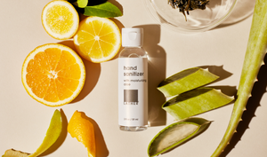 2 ounce hand sanitizer surrounded by slices of citrus and aloe