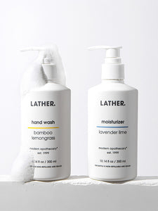 2 white bottles on a ledge with soap on the left bottle 